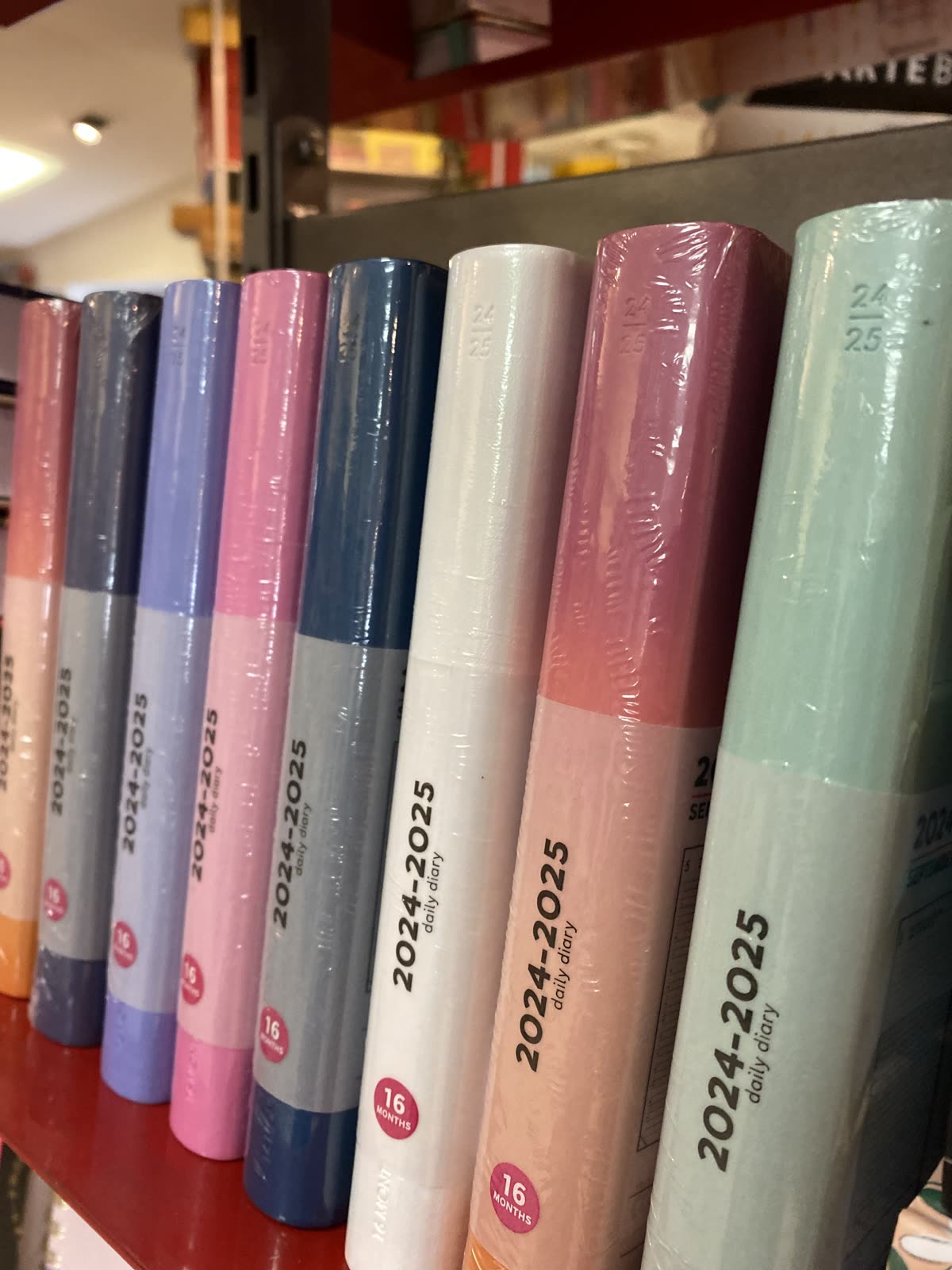 Agende e quaderni in colori pastello esposti in negozio